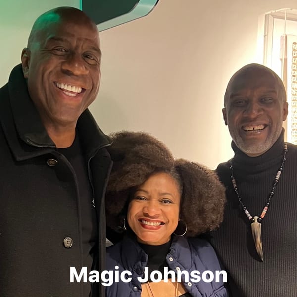 Magic Johnson, a woman, and another man smiling at Cathy's Kitchen.