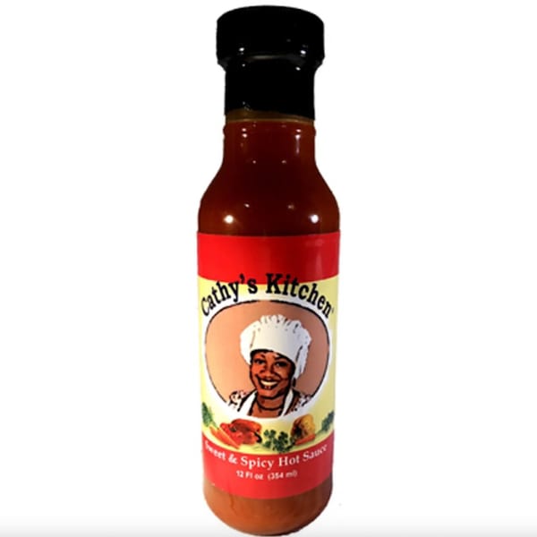 A bottle of Cathy's Kitchen Sweet & Spicy Hot Sauce with a smiling chef on the label.