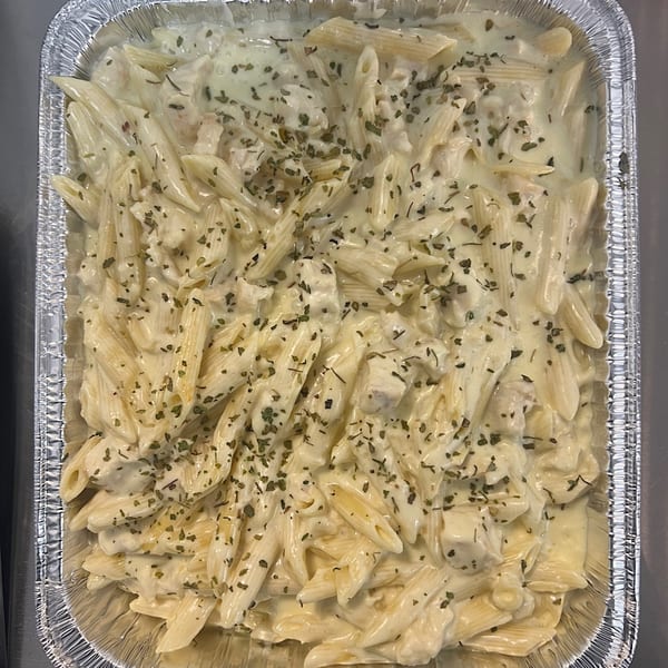 Creamy penne pasta with herbs in a foil baking pan from Cathy's Kitchen.