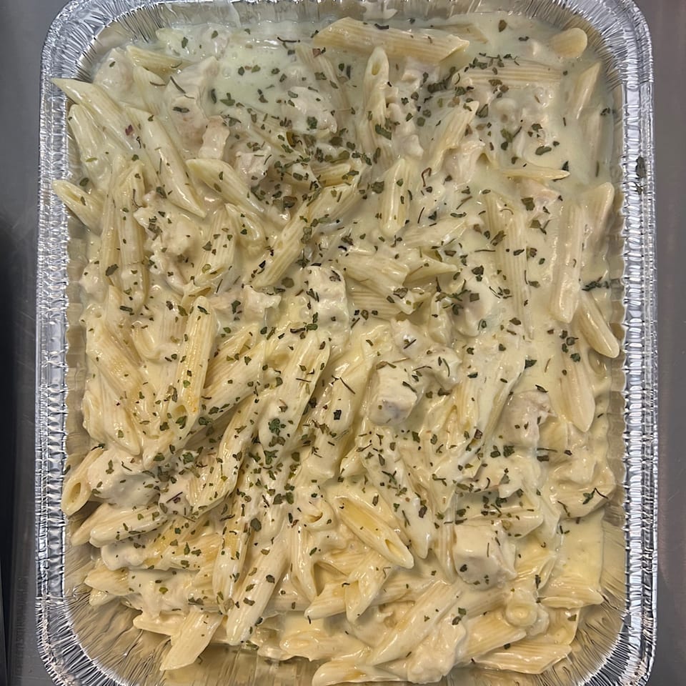 Creamy penne pasta with herbs in a foil baking pan from Cathy's Kitchen.